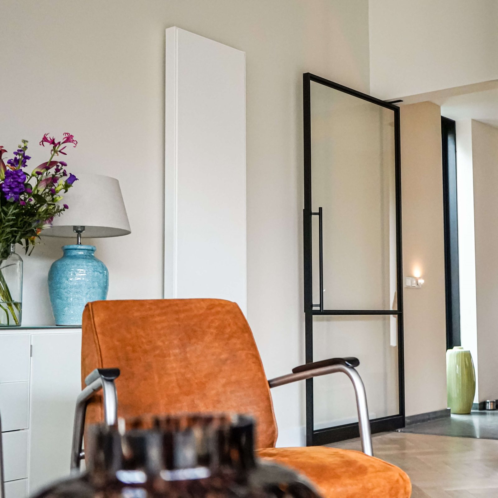 Geöffnete schwarze Loft-Pivottür aus Aluminium und Glas im Wohnraum