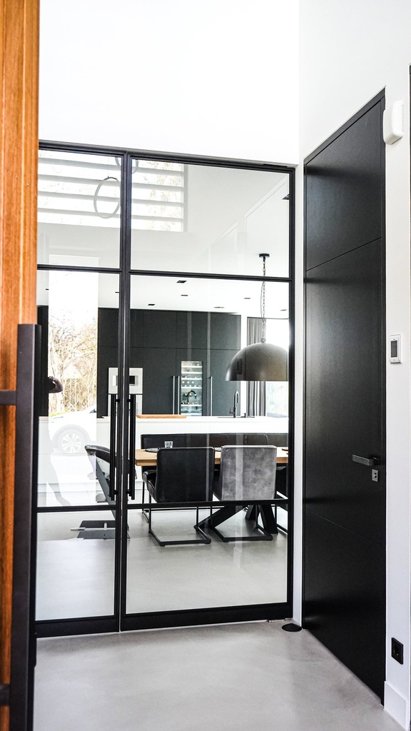 Zweiflügelige Loft-Pivottür mit Sprossen zwischen Flur und Küche